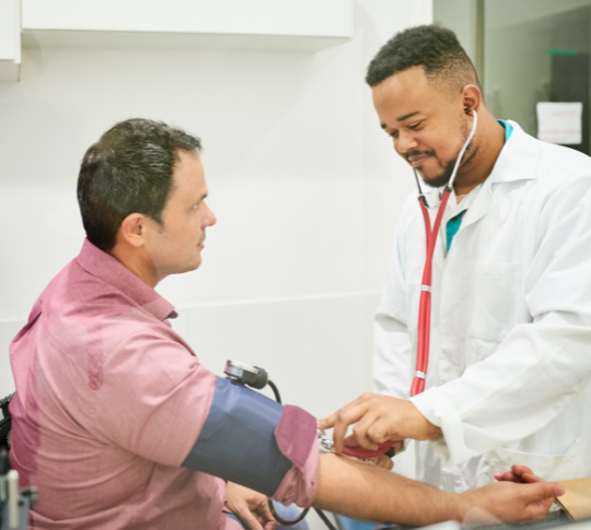 A 45 year old white man getting his blood pressure checked by a 30 year old black doctor with short hair primary care billing service