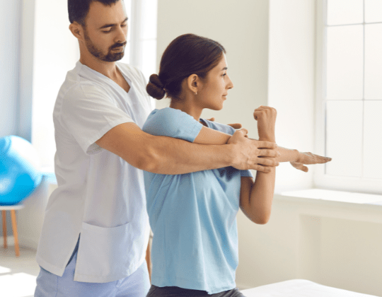 A caucasian man of 35 years old assisting a asian woman of 25 years old with stretching exercises best physical therapy billing services